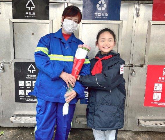 上海市虹口区第四中心小学的杨绾心给社区环卫工人张奶奶（左）送上新年祝福